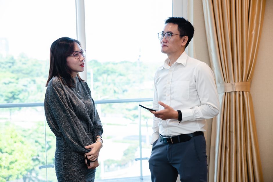 Two colleagues in conversation by a window